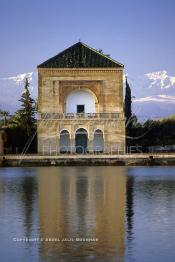 Image du Maroc Professionnelle de  La Ménara est un vaste jardin planté d'oliviers créé au milieu du 12 ème siècle sous le règne de la dynastie Almohade où les visiteurs peuvent s’incliner un moment à l’ombre entre d’innombrables oliviers. Ce pavillon ocre devant les montagnes du Grand Atlas enneigé fait partie des emblèmes de la ville rouge.  Au cœur de ce jardin, un grand bassin au pied d'un pavillon avec son petit toit en forme de pyramide qui peut être à l'origine de son appellation. le Vendredi 19 Décembre 1986. (Photo / Abdeljalil Bounhar)